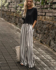 The Travel T in black worn with striped wide-leg pants