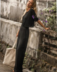 Side view of The Travel T in black with black wide-leg pants
